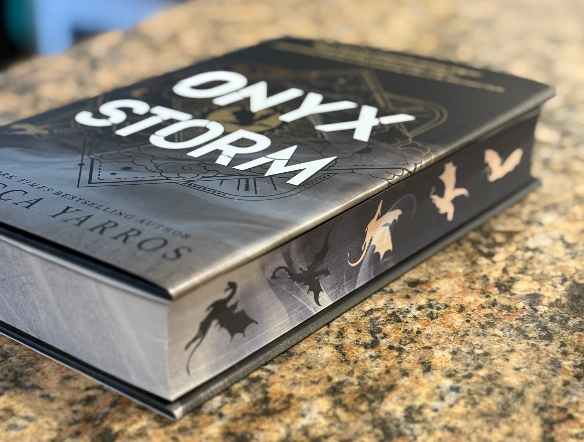 A hardcover copy of Onyx Storm by Rebecca Yarros showing the sprayed edges.